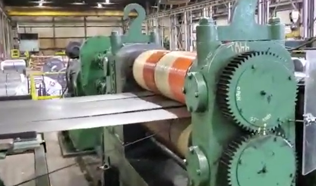 Steel coil being slit into narrow widths on a slitting line